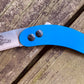 Woods Monkey Banana Peel Neck Knife shown in Blue G10 scale handles and AEB-L steel with a Wharncliffe Blade