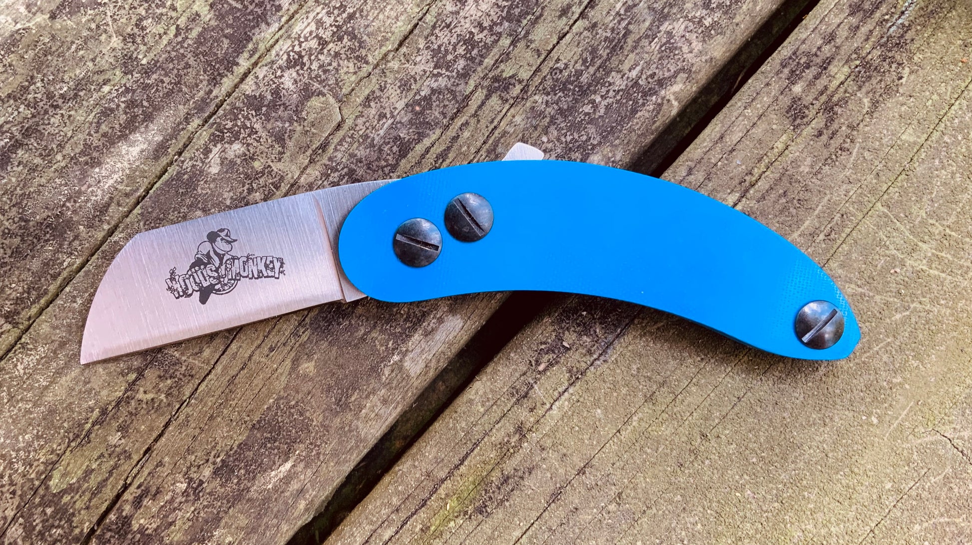 Woods Monkey Banana Peel Neck Knife shown in Blue G10 scale handles and AEB-L steel with a Wharncliffe Blade